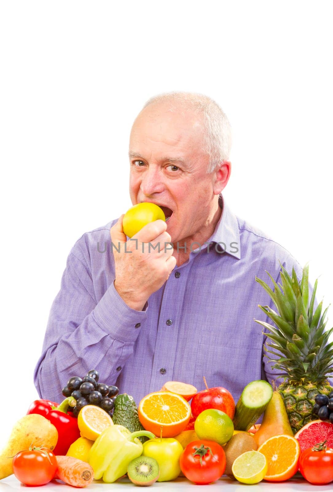 Closeup of senior man eating a green apple against white background