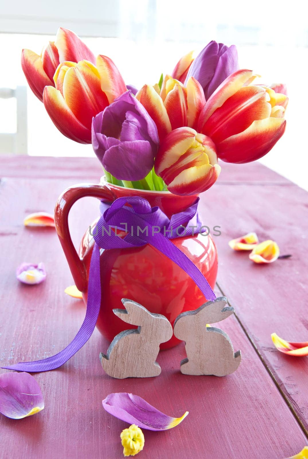 Fresh colorful tulips in small red jug