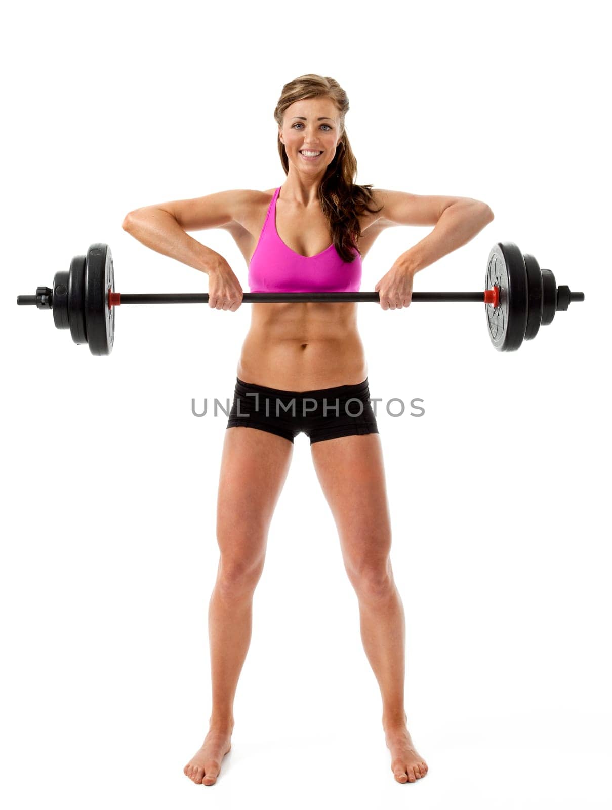 Full length front view of attractive young woman lifting barbell on white background.