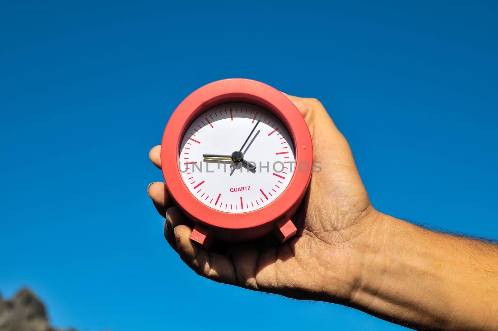 Time Concept White Sand Hourglass on the Volcanic Rocks