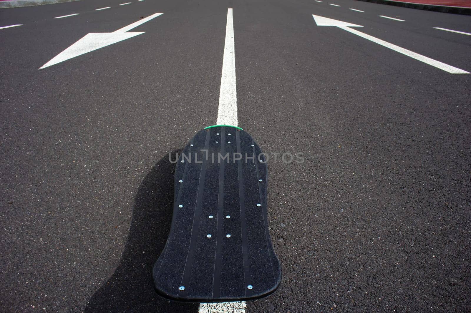 Vintage Style Longboard Black Skateboard on an Empty Asphalt Desert Road