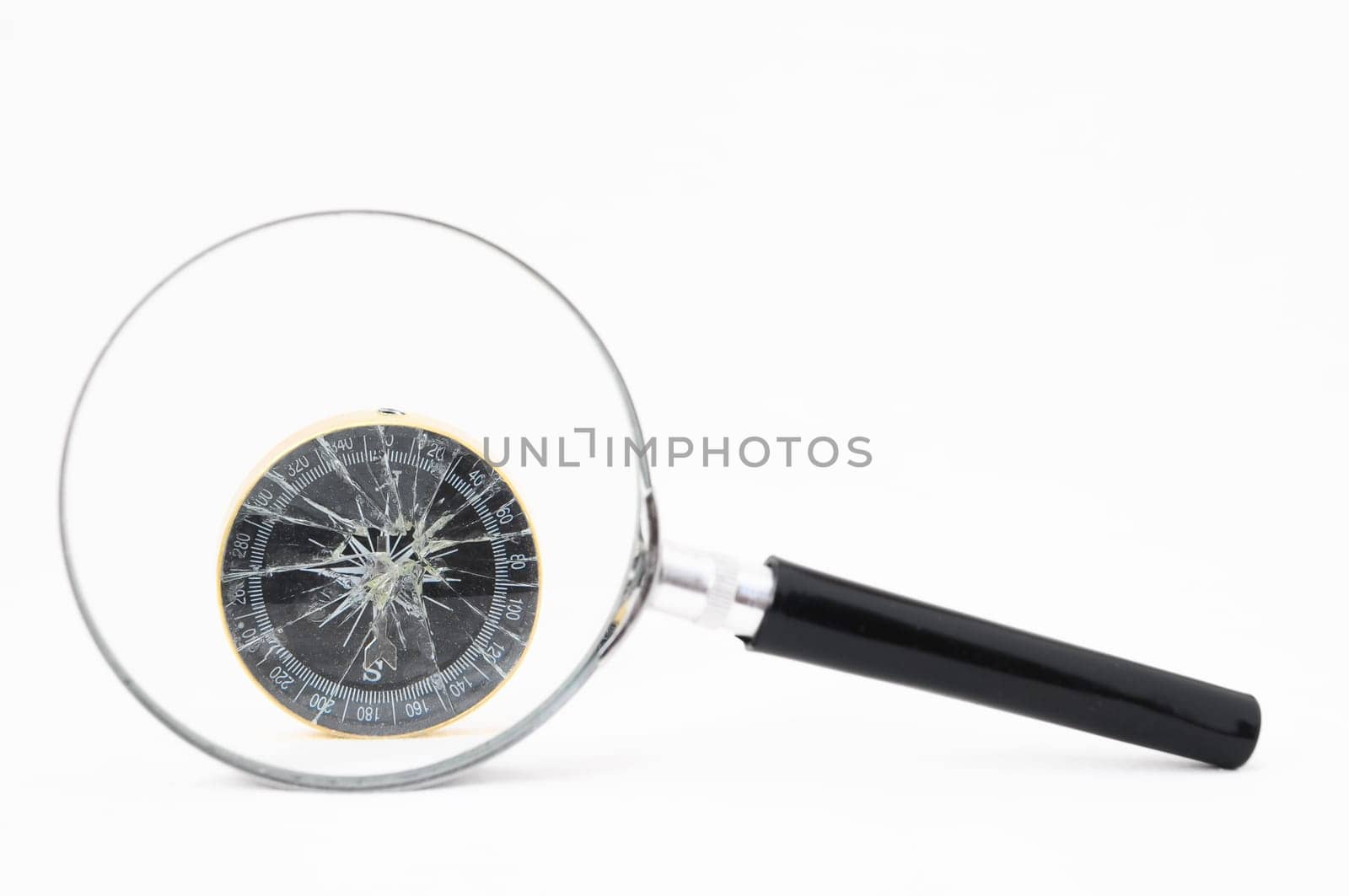 Orientation Concept - Analogic Compass and Loupe on a White Background