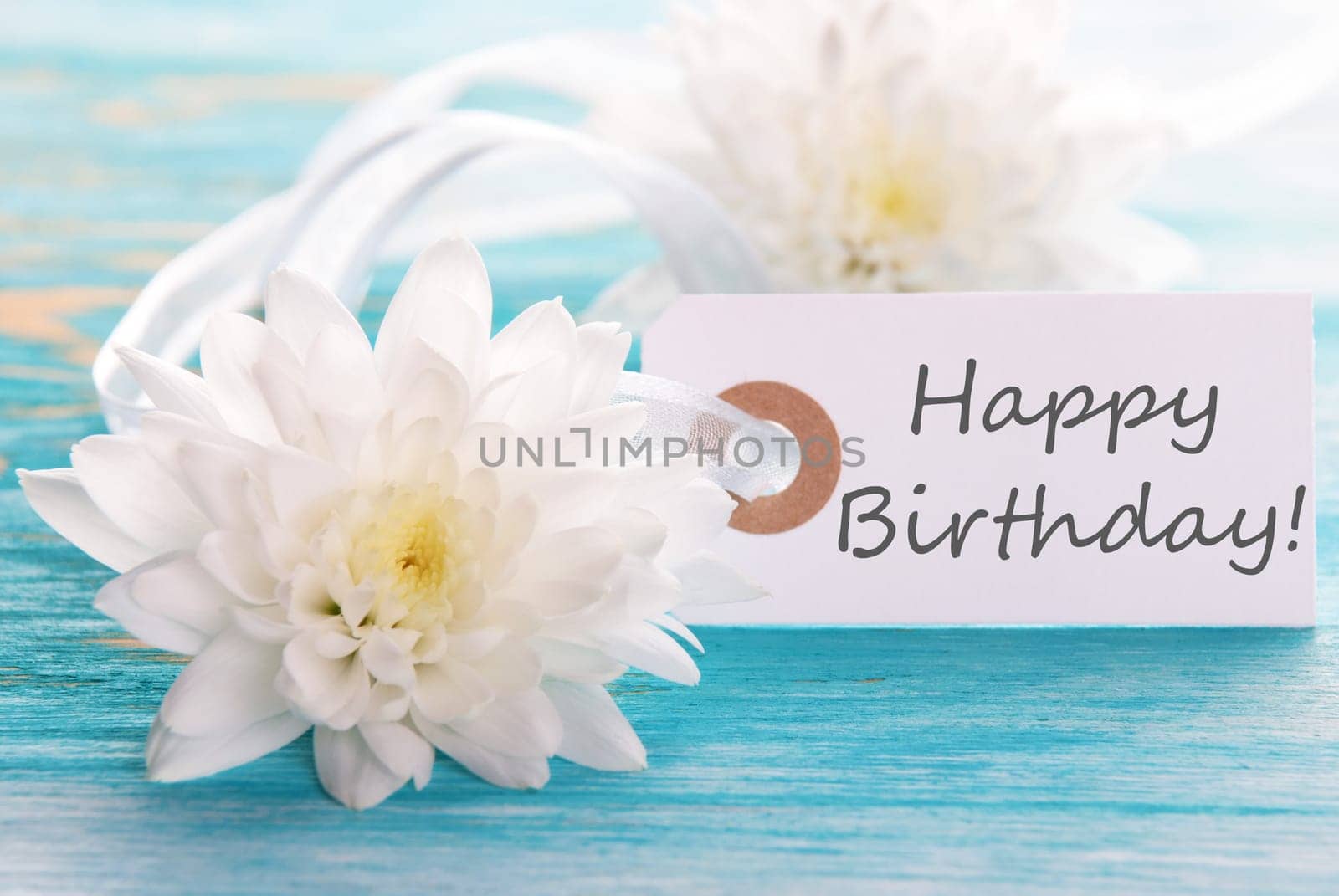 Label with Happy Birthday on wooden turquiose Background with white Flowers