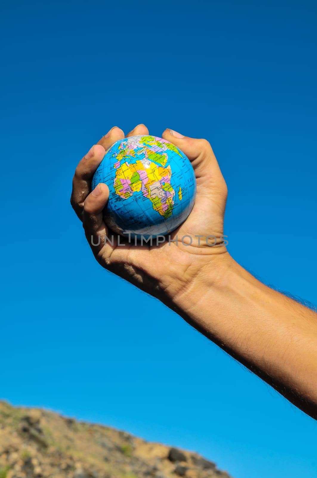 Vintage Old Globe Earth and Human Hand over a Blue Sky