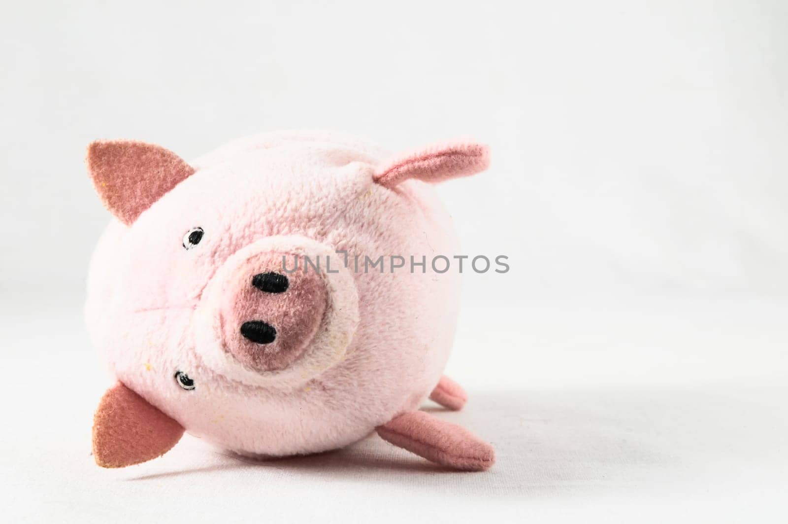 The pink pig cloth figurine on a white background