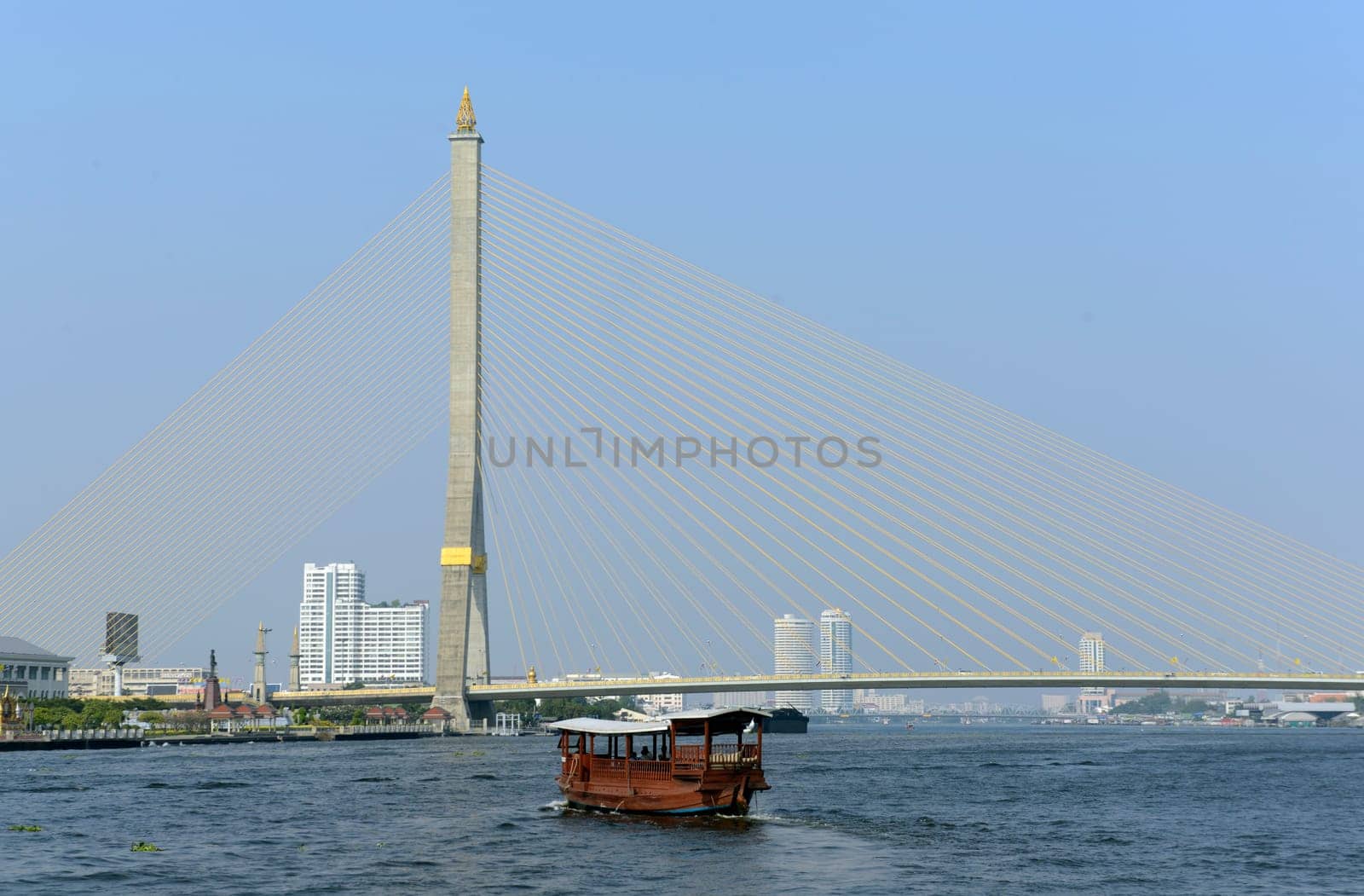 A traditional wooden boat at the Bruecke Saphan Phra Ram Vlll on the Mae Nam Chao Phraya River in the capital Bangkok of Thailand in South East Asia.