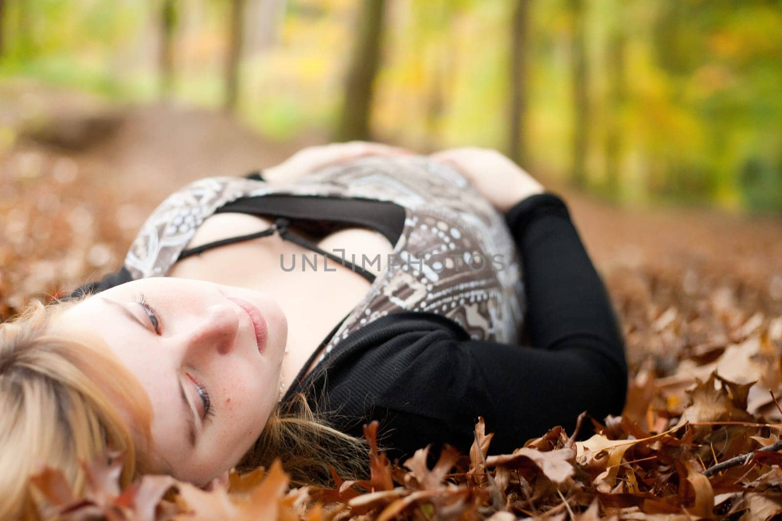 Blond young girl is waiting for her little child. Shoot in the forest