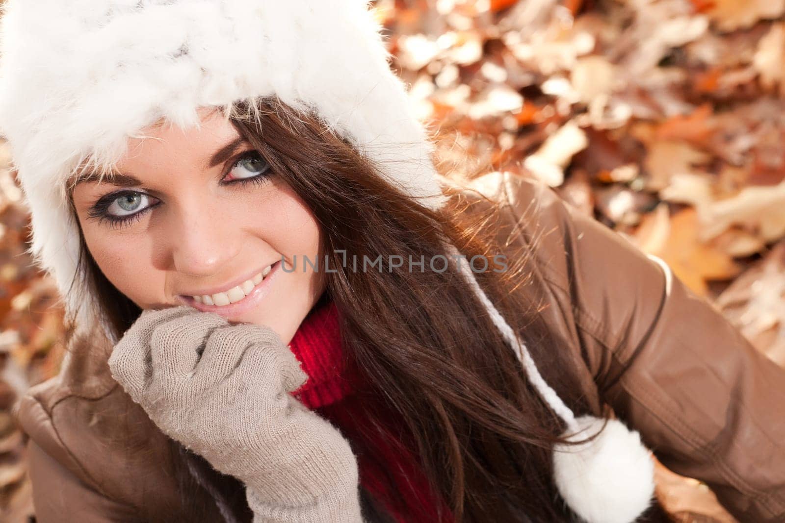 Happy brunette is having a nice time in the park while it's autumn