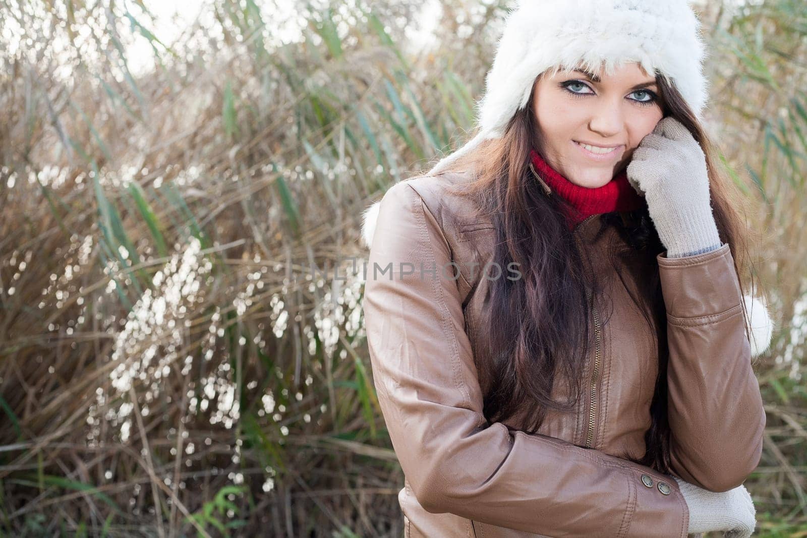 Happy brunette is having a nice time in the park while it's autumn