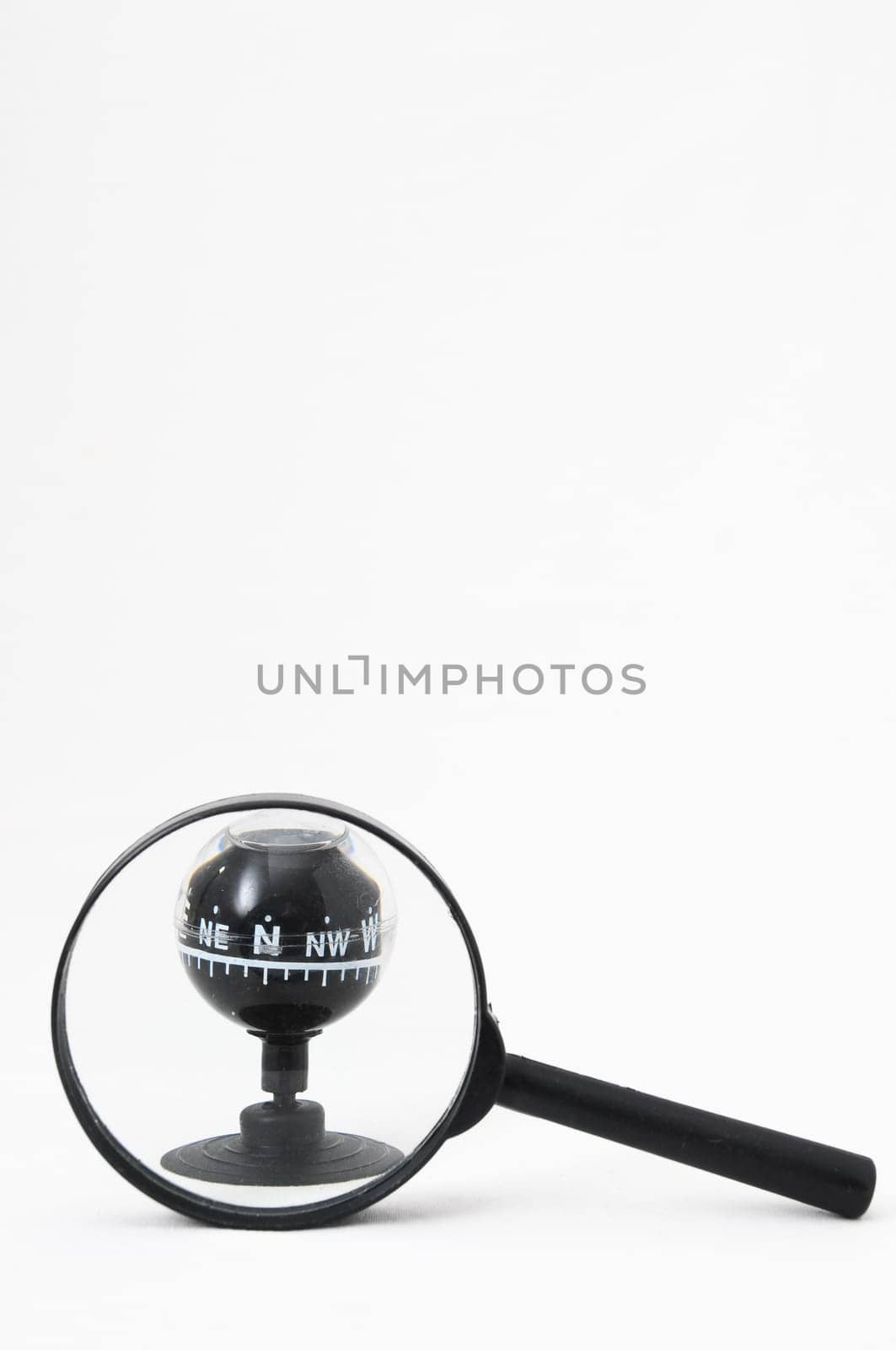 Orientation Concept - Analogic Compass and Loupe on a White Background