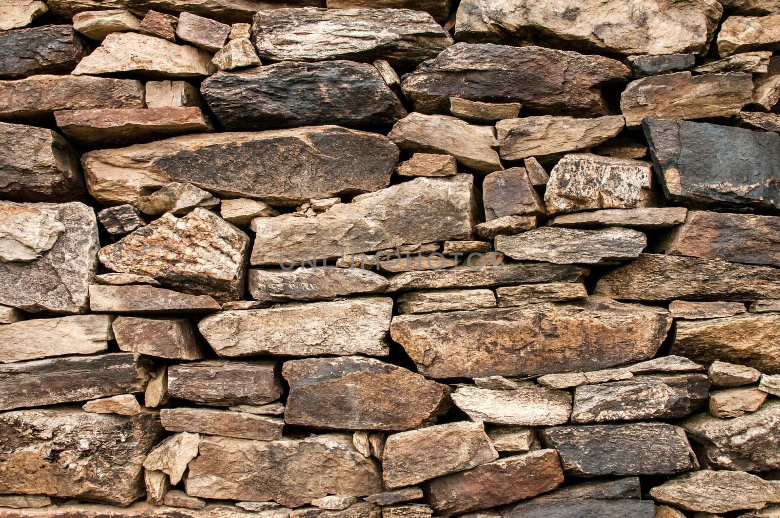 Dry masonry stone wall closeup as background