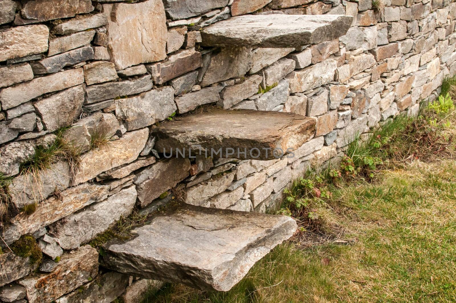 Stone steps into garden dry masonry stonewall closeup