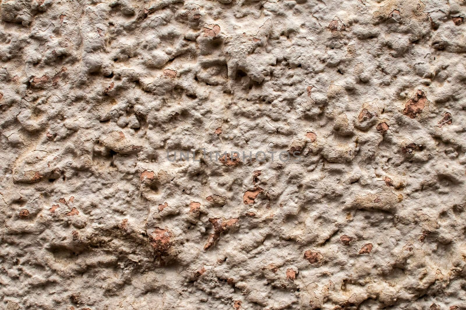 Old weathered plaster wall of village house closeup as background