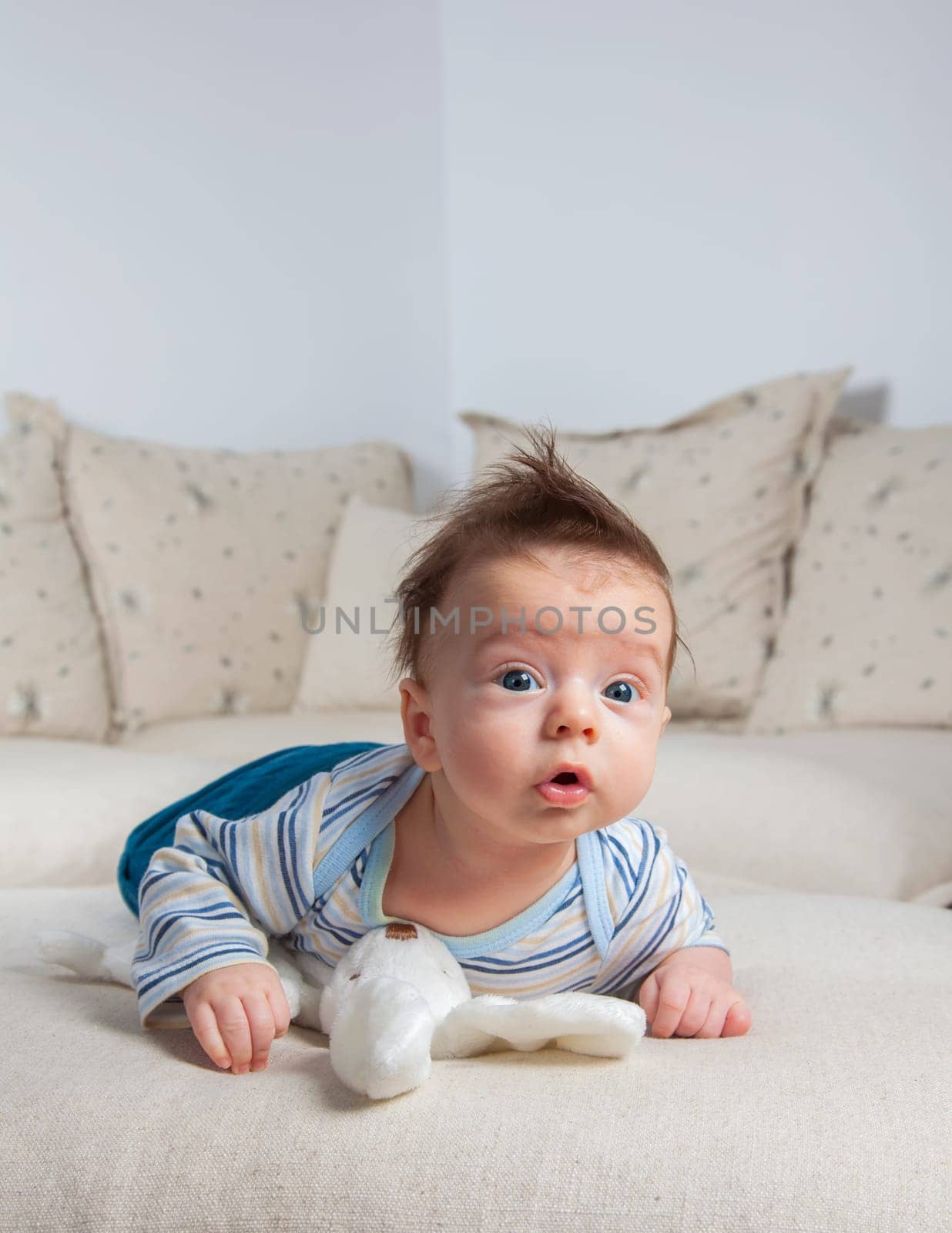 3 months old baby boy portrait at home laying on is tummy.