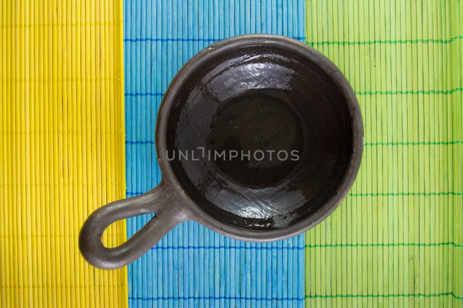 Mexican Oaxacan pottery bowl brown color on tablecloth made ​​of wooden branches.