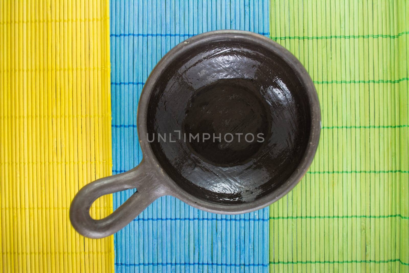 Mexican Oaxacan pottery bowl brown color on tablecloth made ​​of wooden branches.