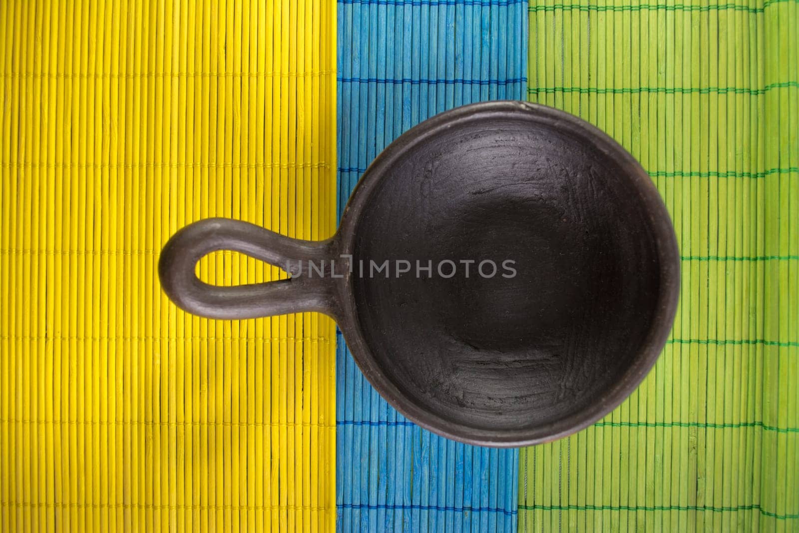 Mexican Oaxacan pottery bowl brown color on tablecloth made ​​of wooden branches.