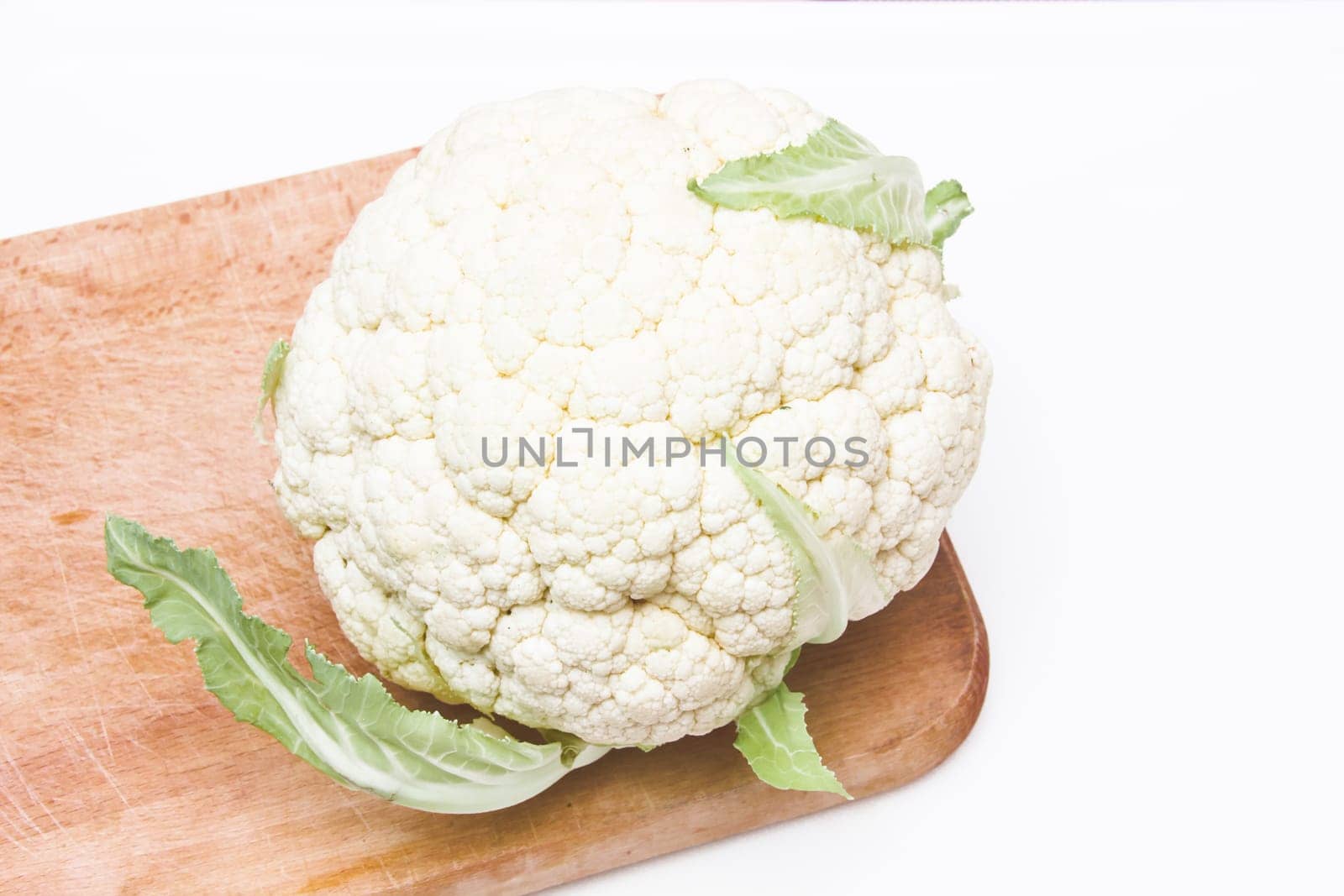 Cauliflower on a cutting board on white background