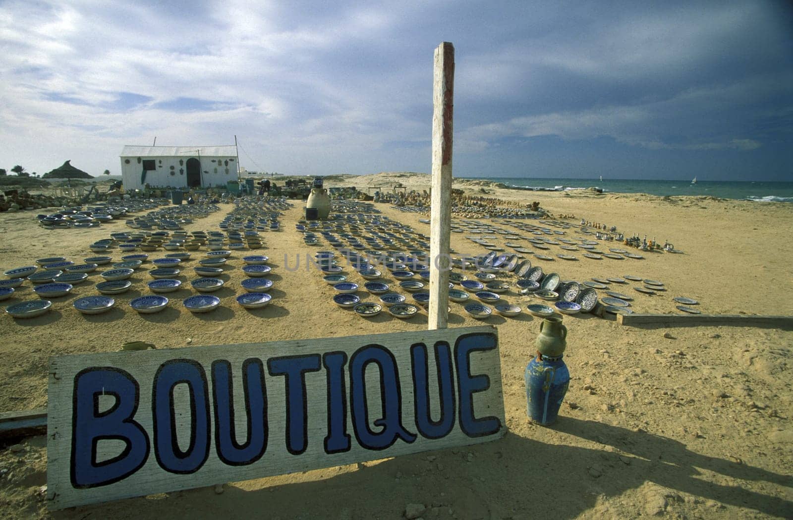 A sandy beach with boutique on the island of Jerba on the Mediterranean Sea in Tunisia in North Africa.