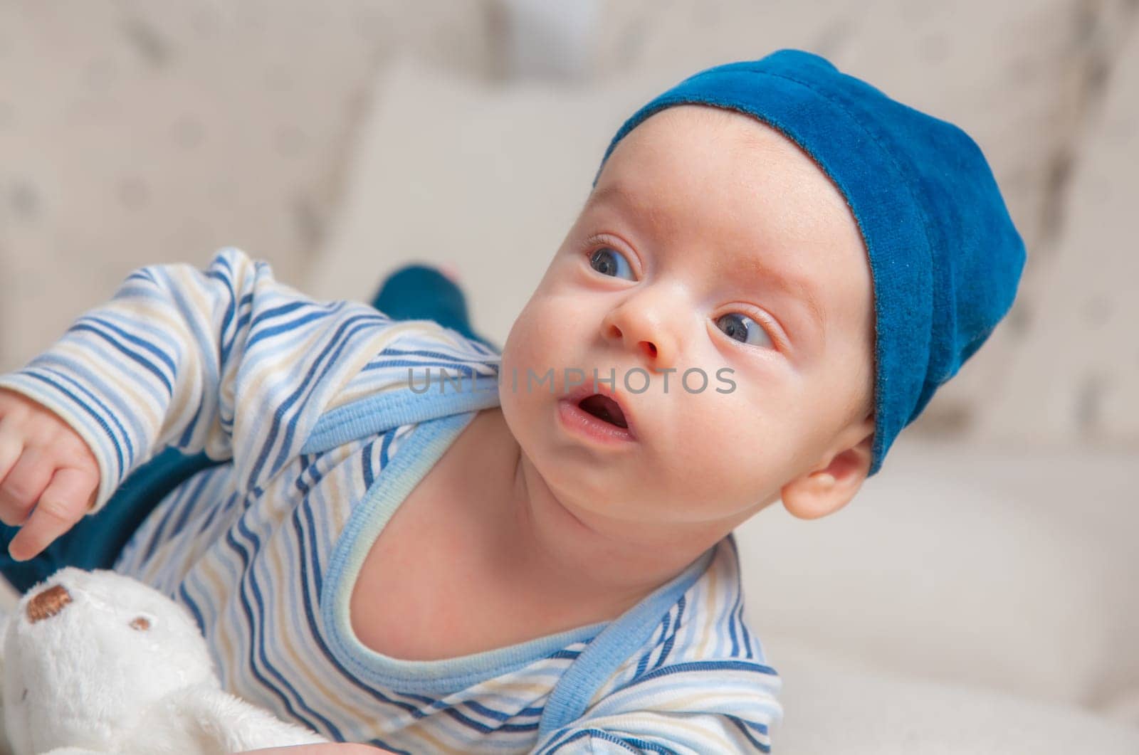 3 months old baby boy portrait at home trying to roll over.