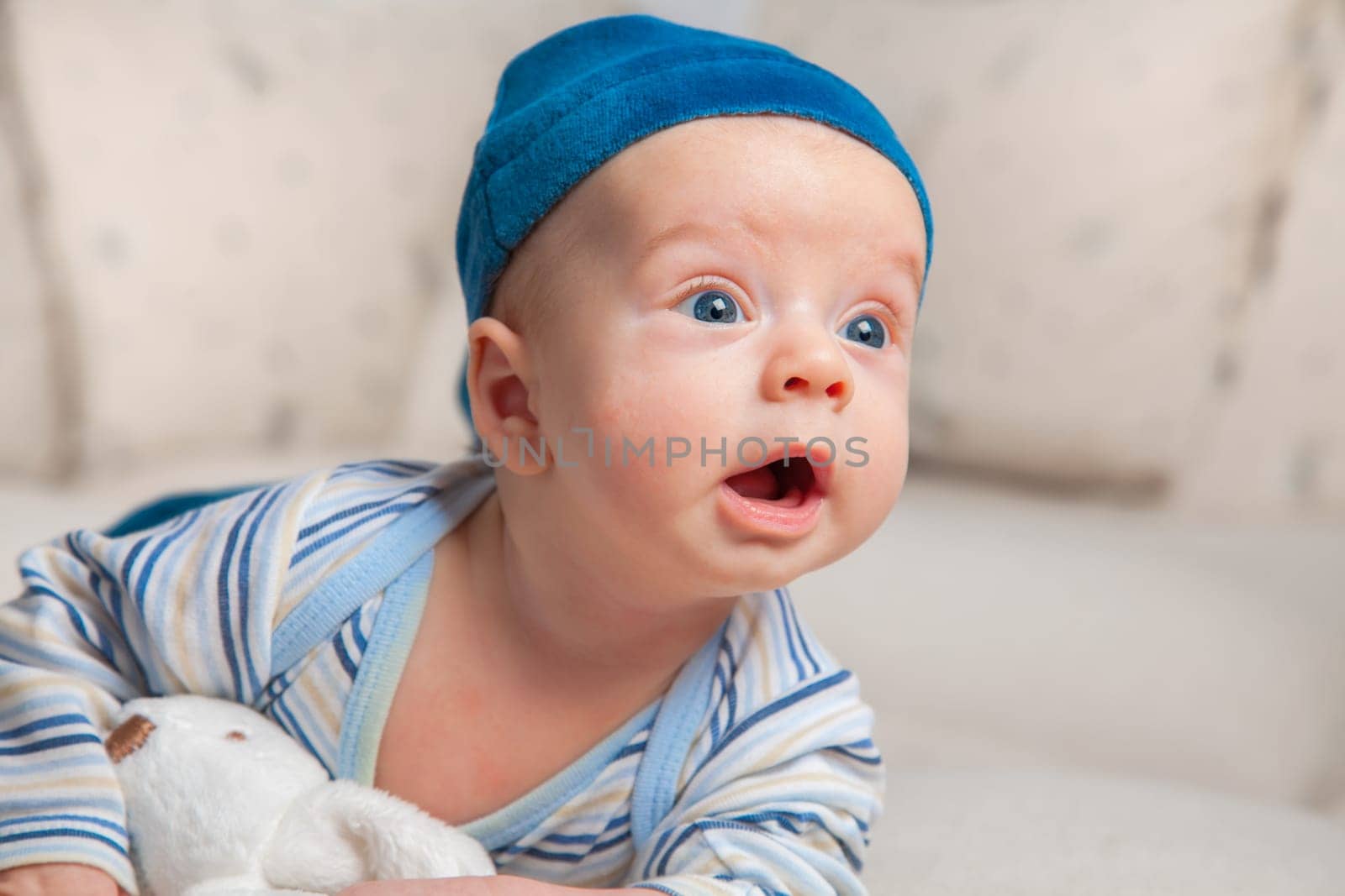 3 months old baby boy portrait at home trying to roll over.