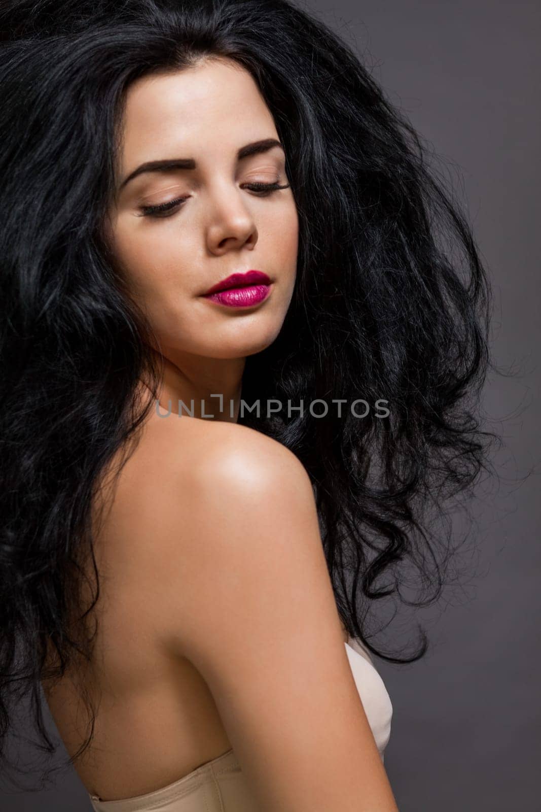 young attractive woman with red lips and dark curly hair with lots of volume portraitboy attractive woman with red lips and dark curly hair with lots of volume portrait