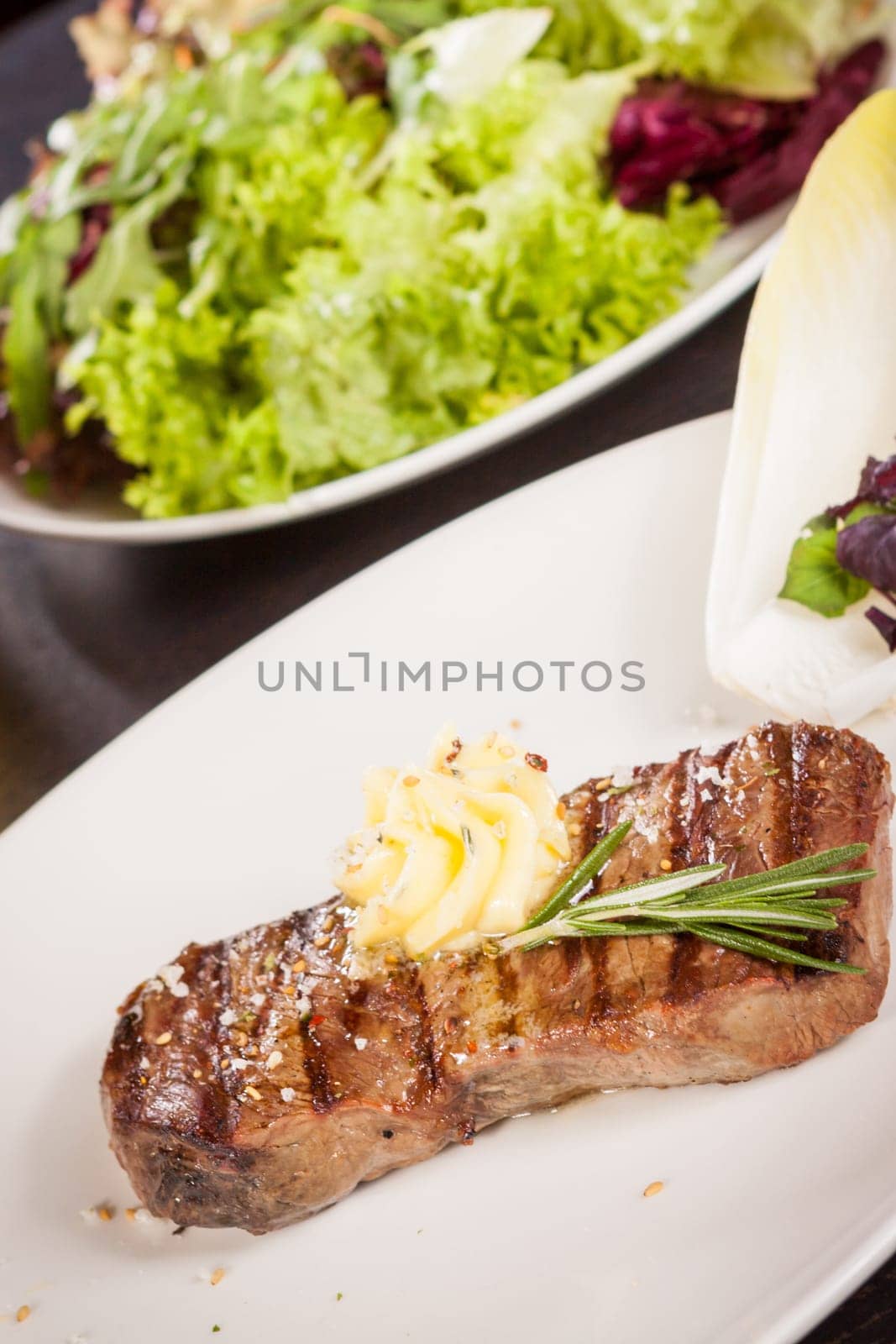 Succulent grilled beef fillet steak with homemade herb butter on a plate