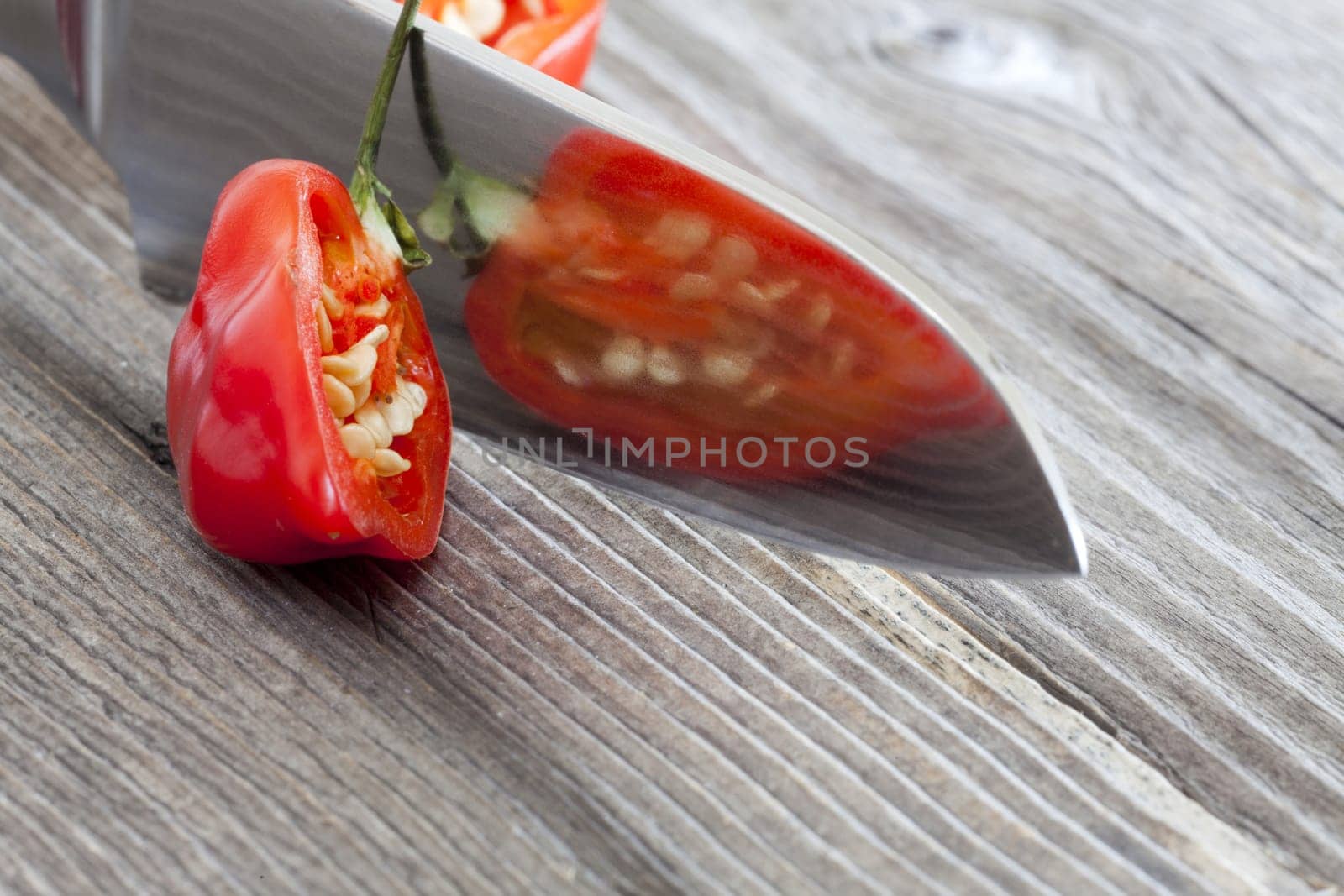 Halved Habanero chili pepper is reflected in the knife