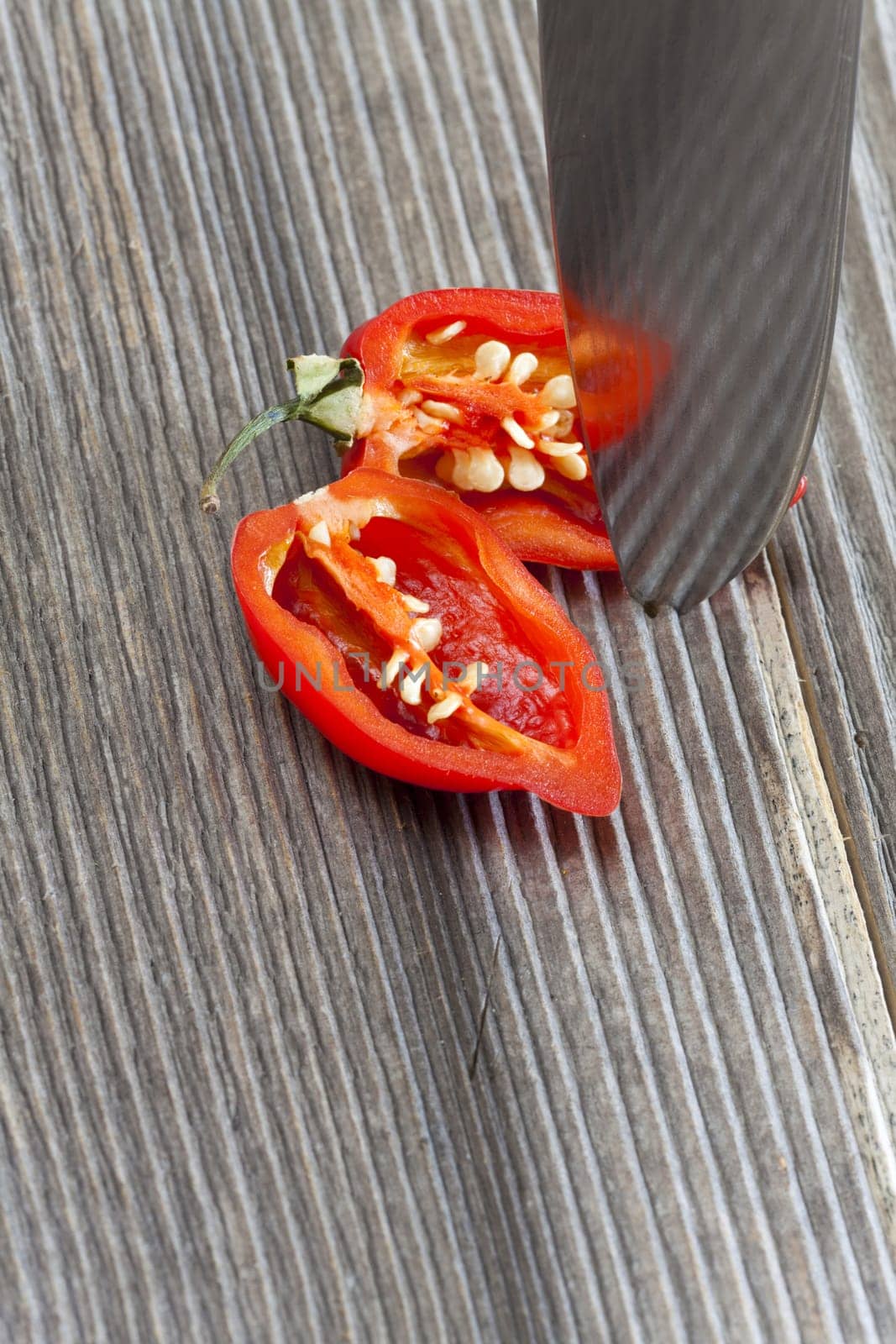 Halved Habanero chili pepper on wooden substrate