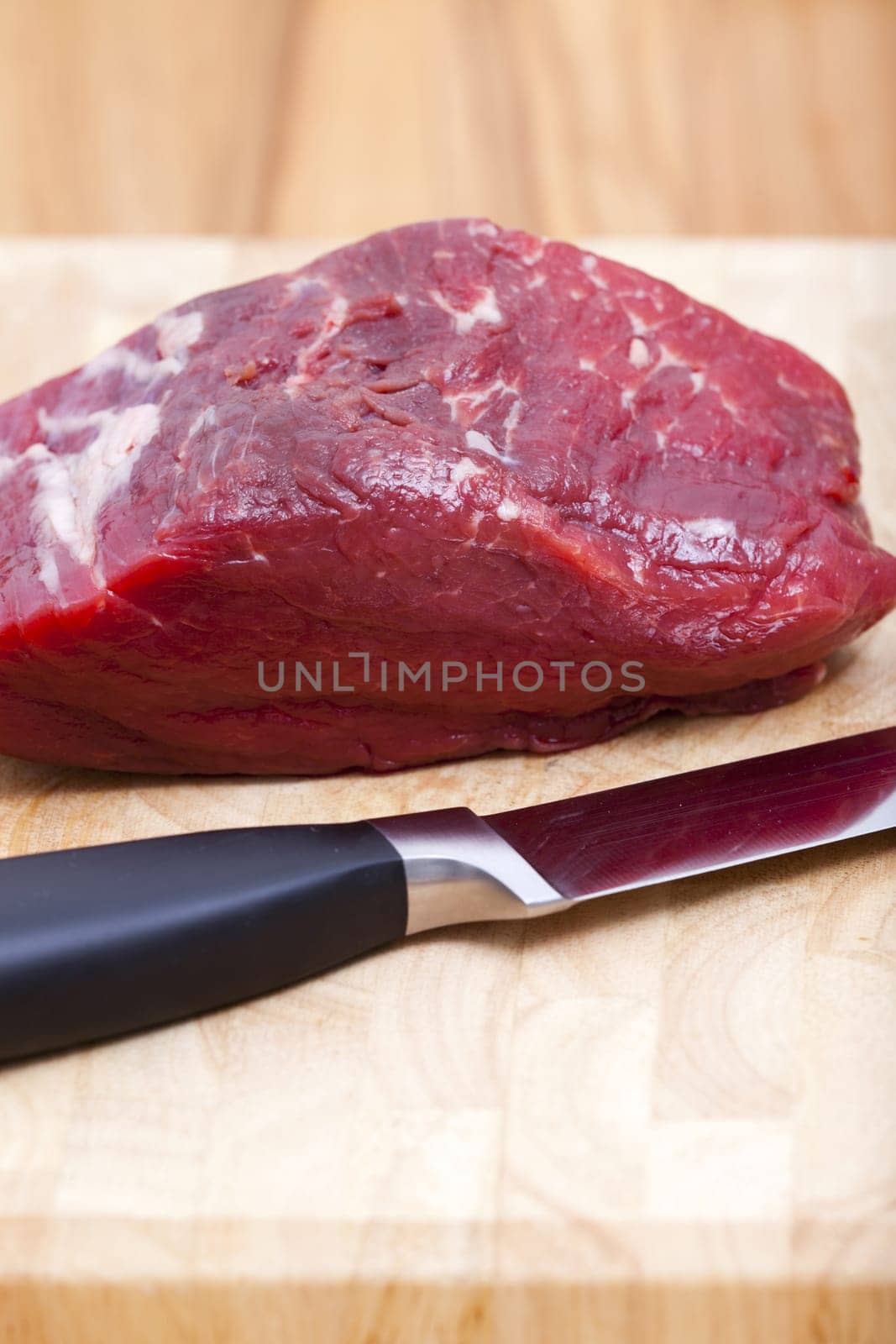 Close-up beef fillet with kitchen knife