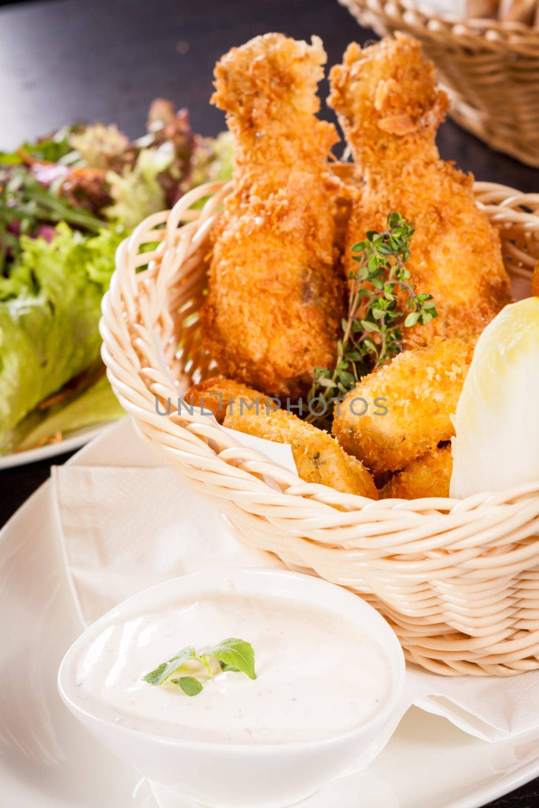 Crispy fried chicken wings with a dip on a plate