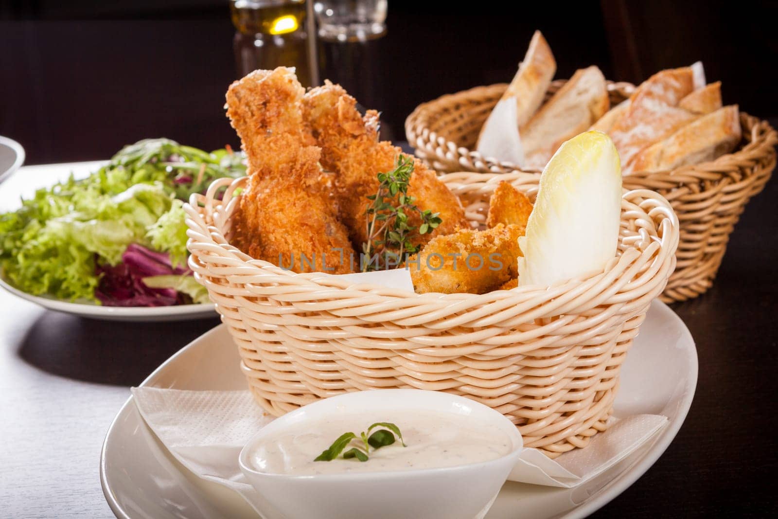 Crispy fried chicken wings with a dip on a plate