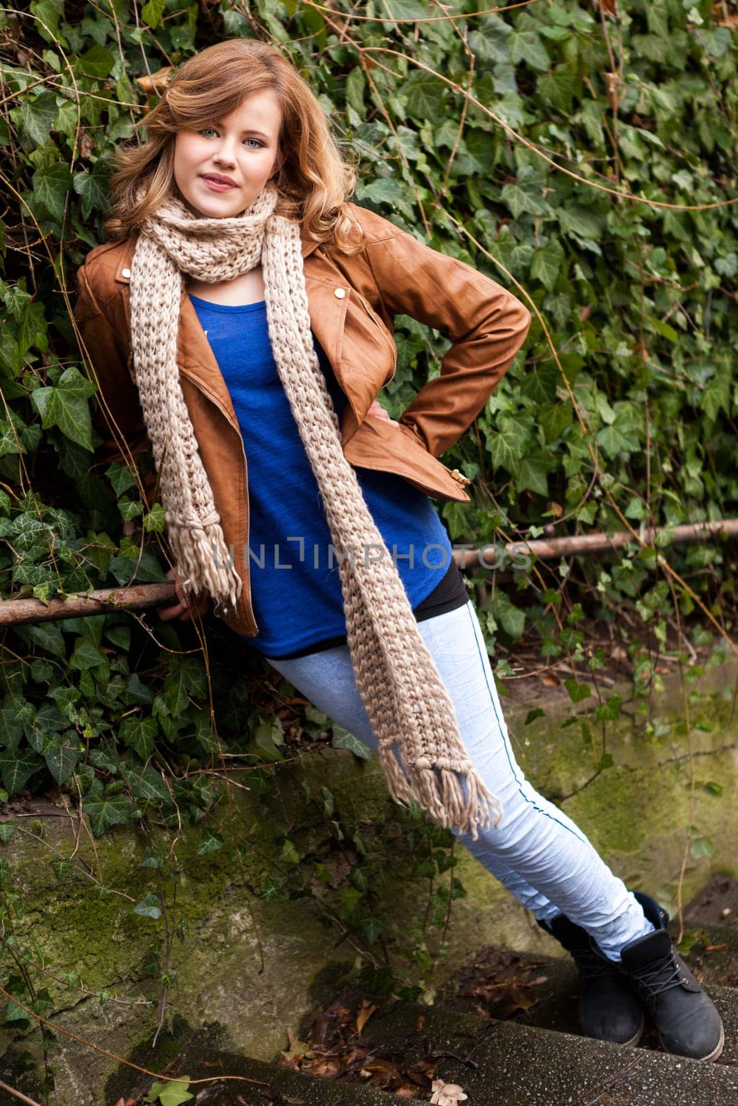 Pretty young woman teen on a road with vehicles outdoors in autumn