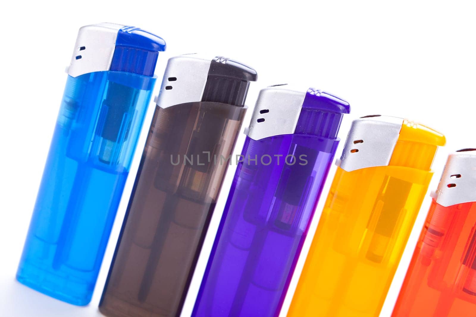 Series of different coloured lighters with electric piezo ignition insulated against white background