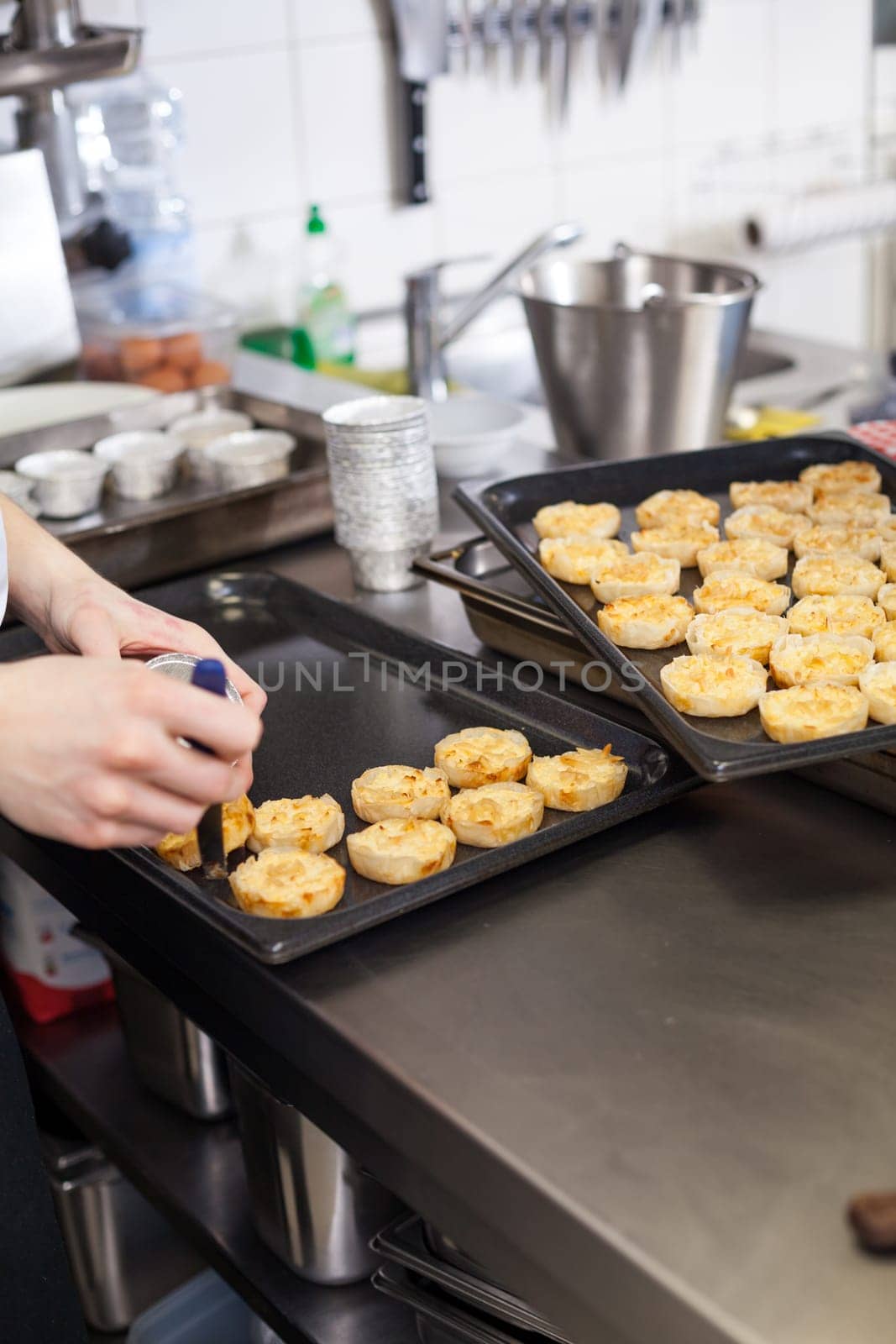 chef solves freshly baked tarts from the mould in the kitchen restaurant pastry shop