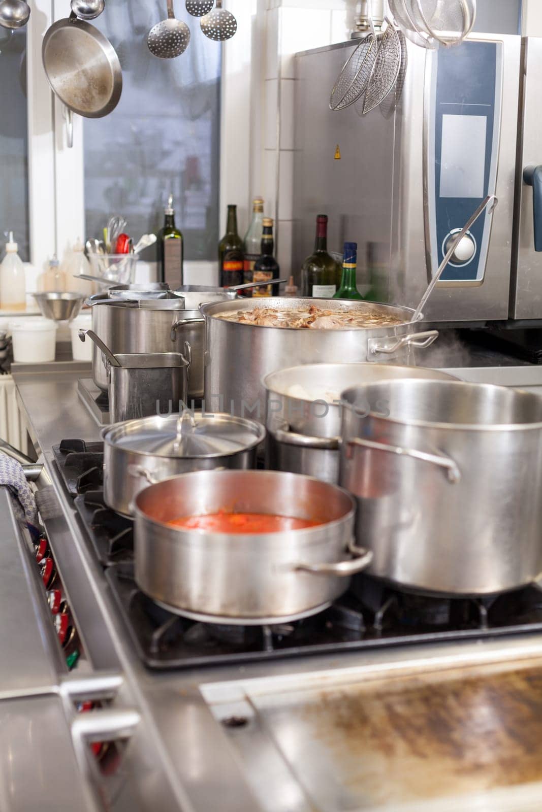 gastronomy restaurant kitchen with hob and steaming pots while cooking to prepare dinner dinner