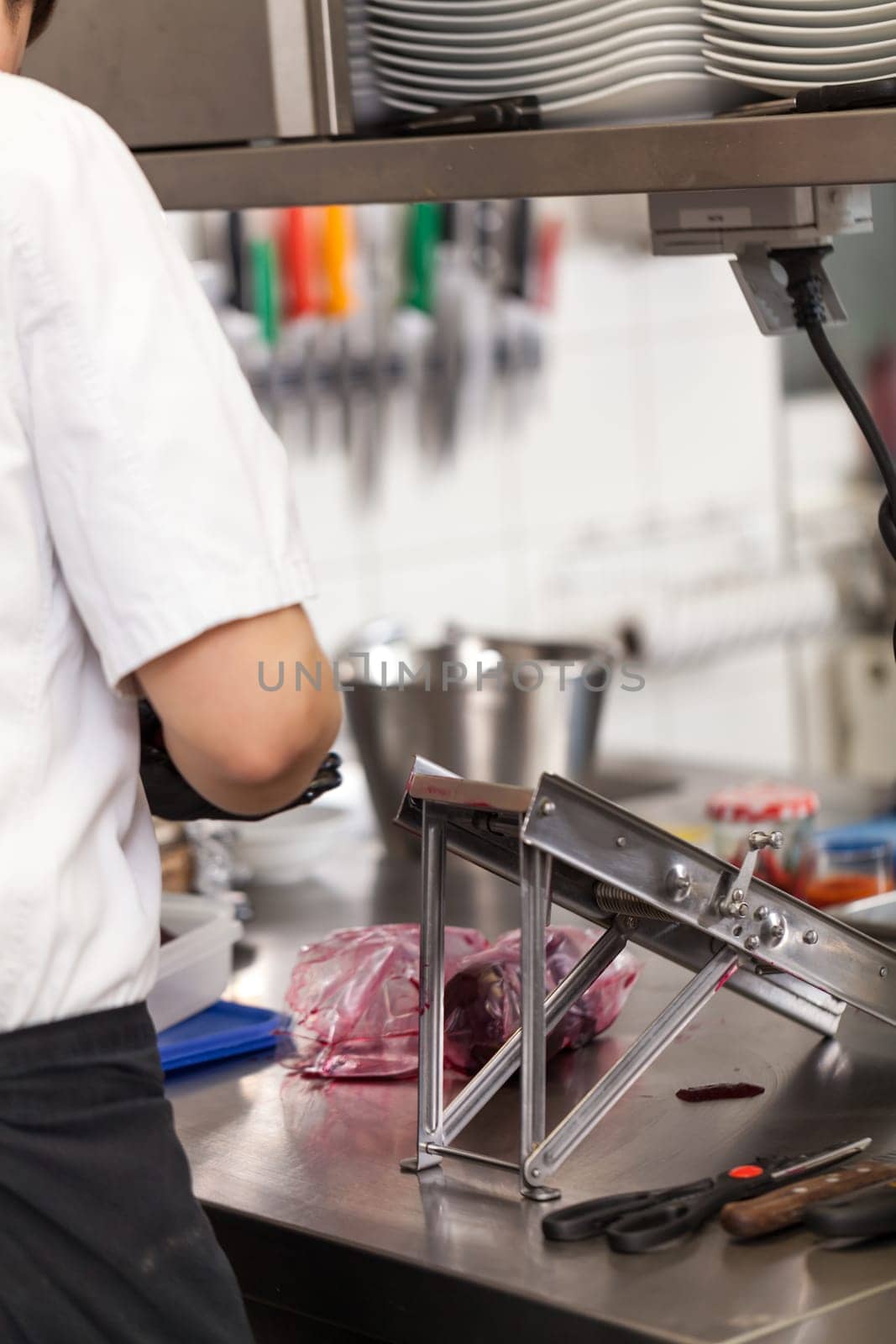 cook rubs fresh red beetroot on rub with gloves to protect against stains in the restaurant kitchen preparation eat