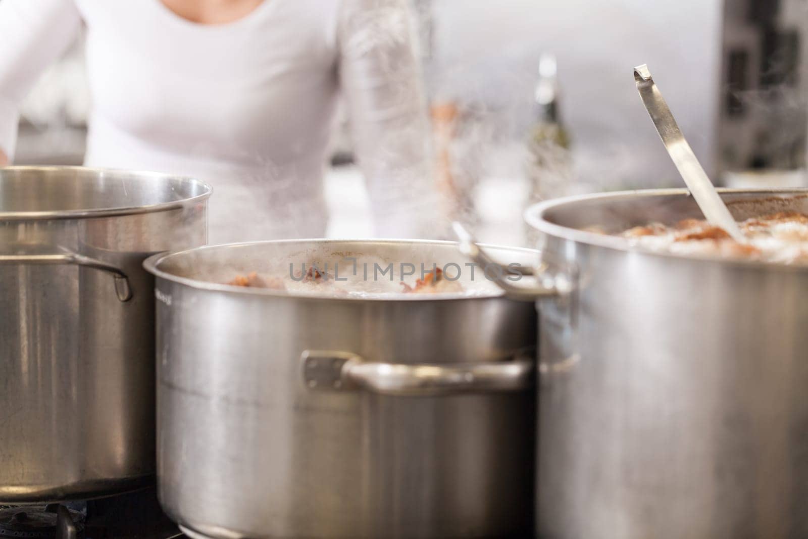 gastronomy restaurant kitchen with hob and steaming pots while cooking to prepare dinner dinner