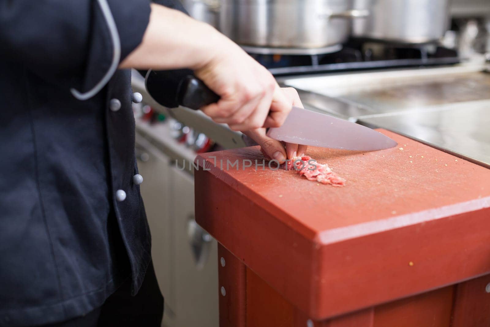 chef cuts fresh red meat in the restaurant kitchen gastronomy food work cooking