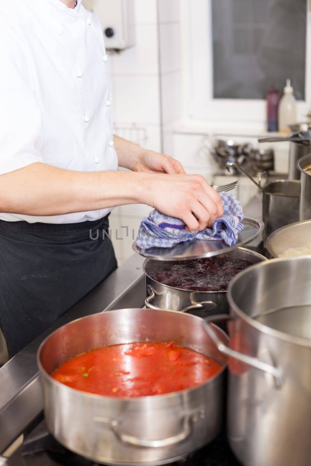 gastronomy restaurant kitchen with hob and steaming pots while cooking to prepare dinner dinner