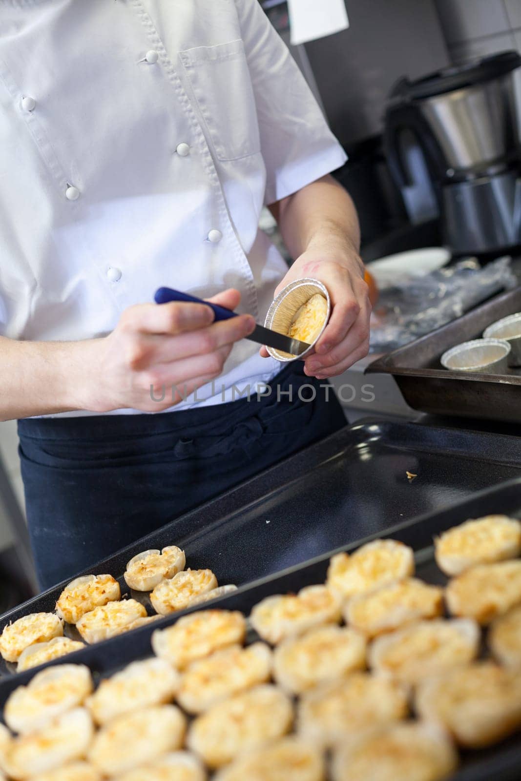 chef solves freshly baked tarts from the mould in the kitchen restaurant pastry shop