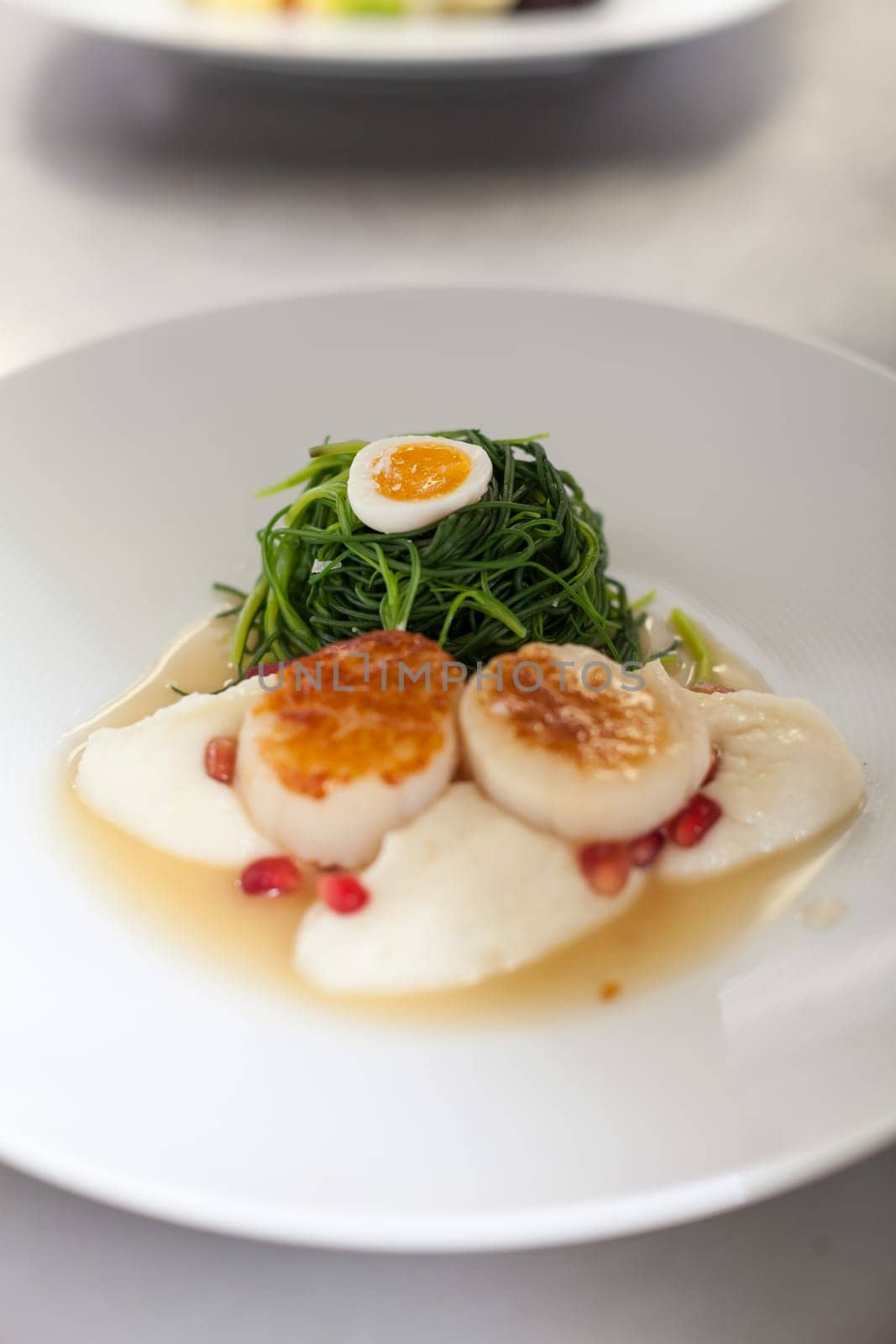 gourmet food with scallops and quail eggs and puree prepared with sauce