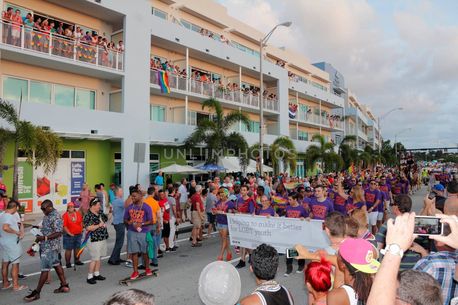 WILTON MANORS, FLORIDA - JUNE 22, 2013: Gay, Lesbian and Straight Education Network members and supporters walk through the crowd at the gay pride parade with many waving rainbow flags on Wilton Drive