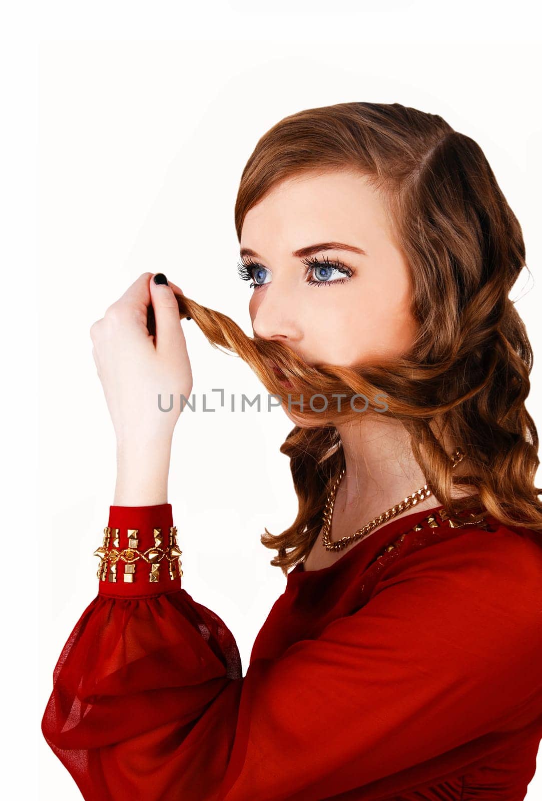 A lovely young woman in a red dress holding some hair on her mouth, standing.for white background..