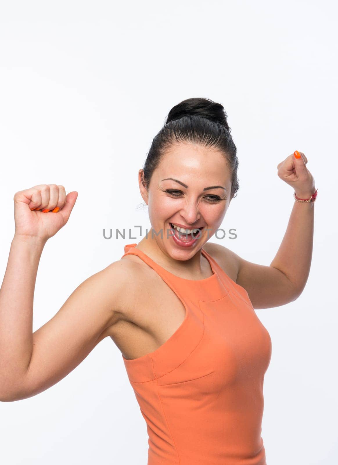 Portrait of beautiful caucasian woman wearing orange dress happy and full of energy