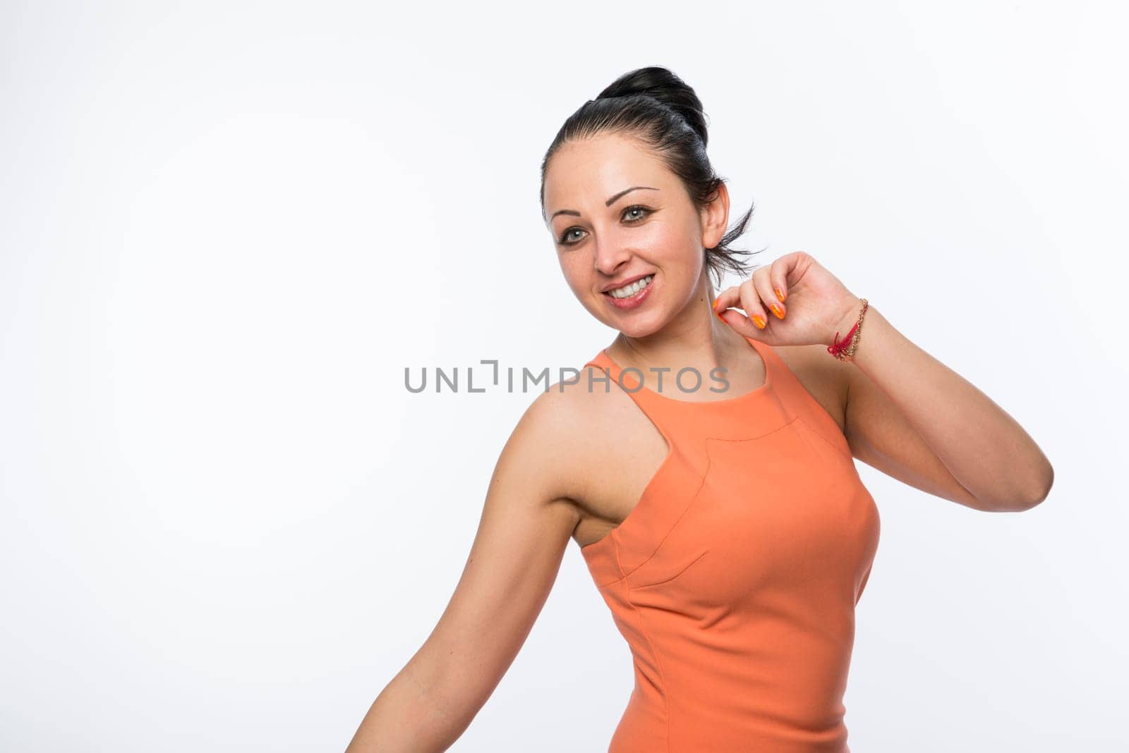 Portrait of beautiful caucasian woman wearing orange dress happy and full of energy