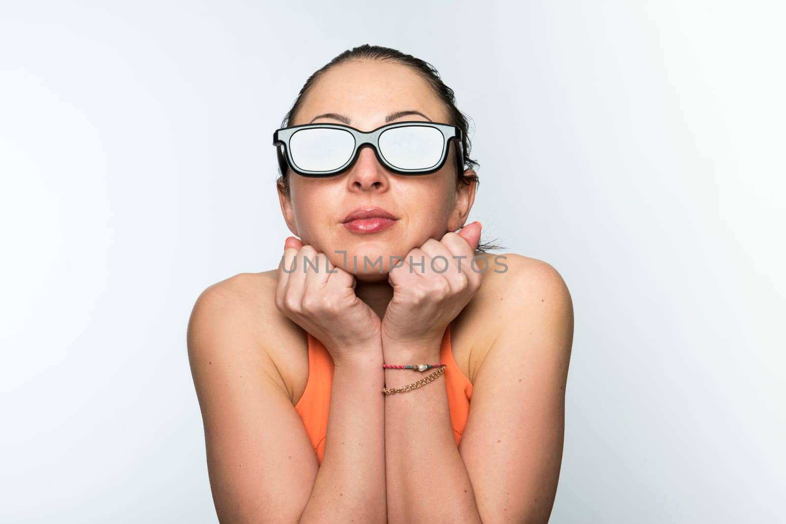 Portrait of beautiful caucasian woman wearing large 3D cinema glasses looking enthralled