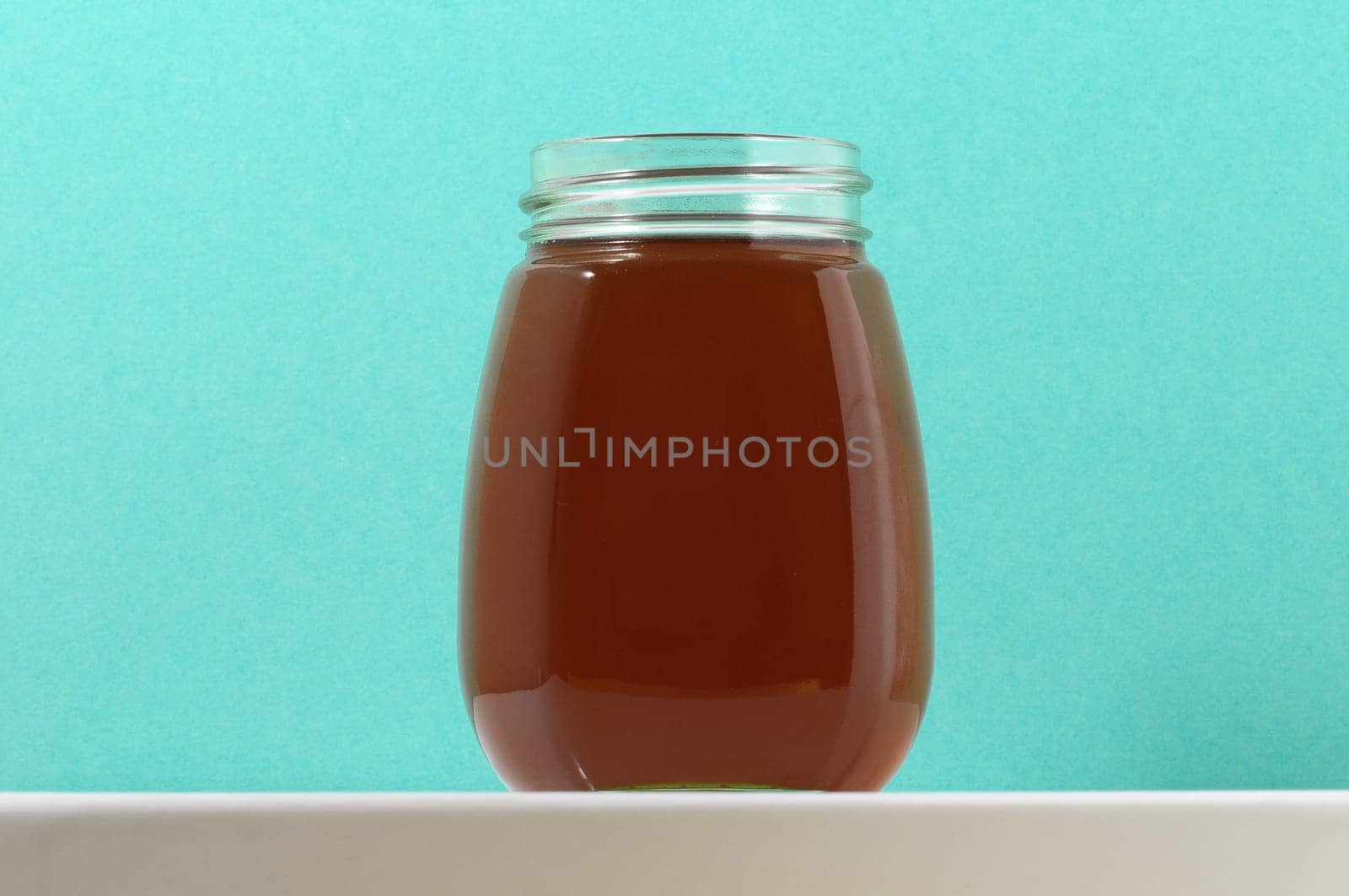 One Full Honey Jar on a Colored Background