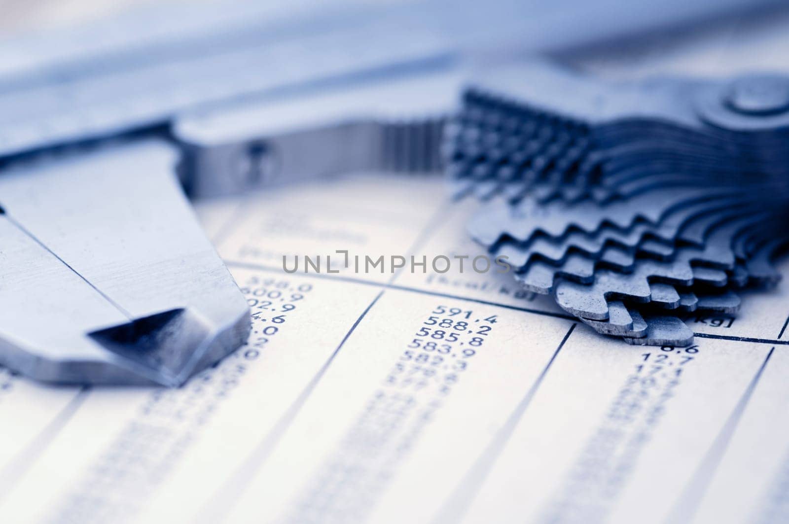Detailed view with low depth of field of a measuring slider and a thread gauge on a number table
