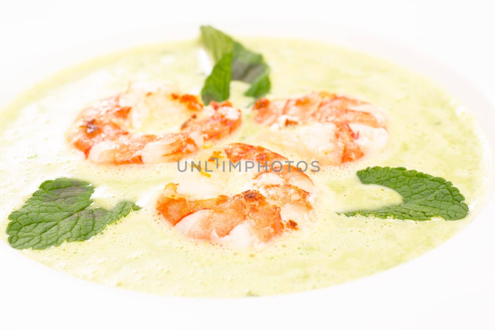Close-up shrimp and green soup with mint